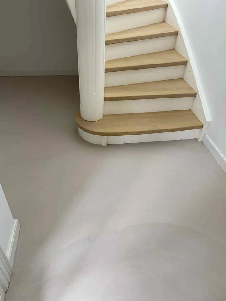 Seamless microcement floor in a Costa del Sol bathroom — soft blue-grey satin finish