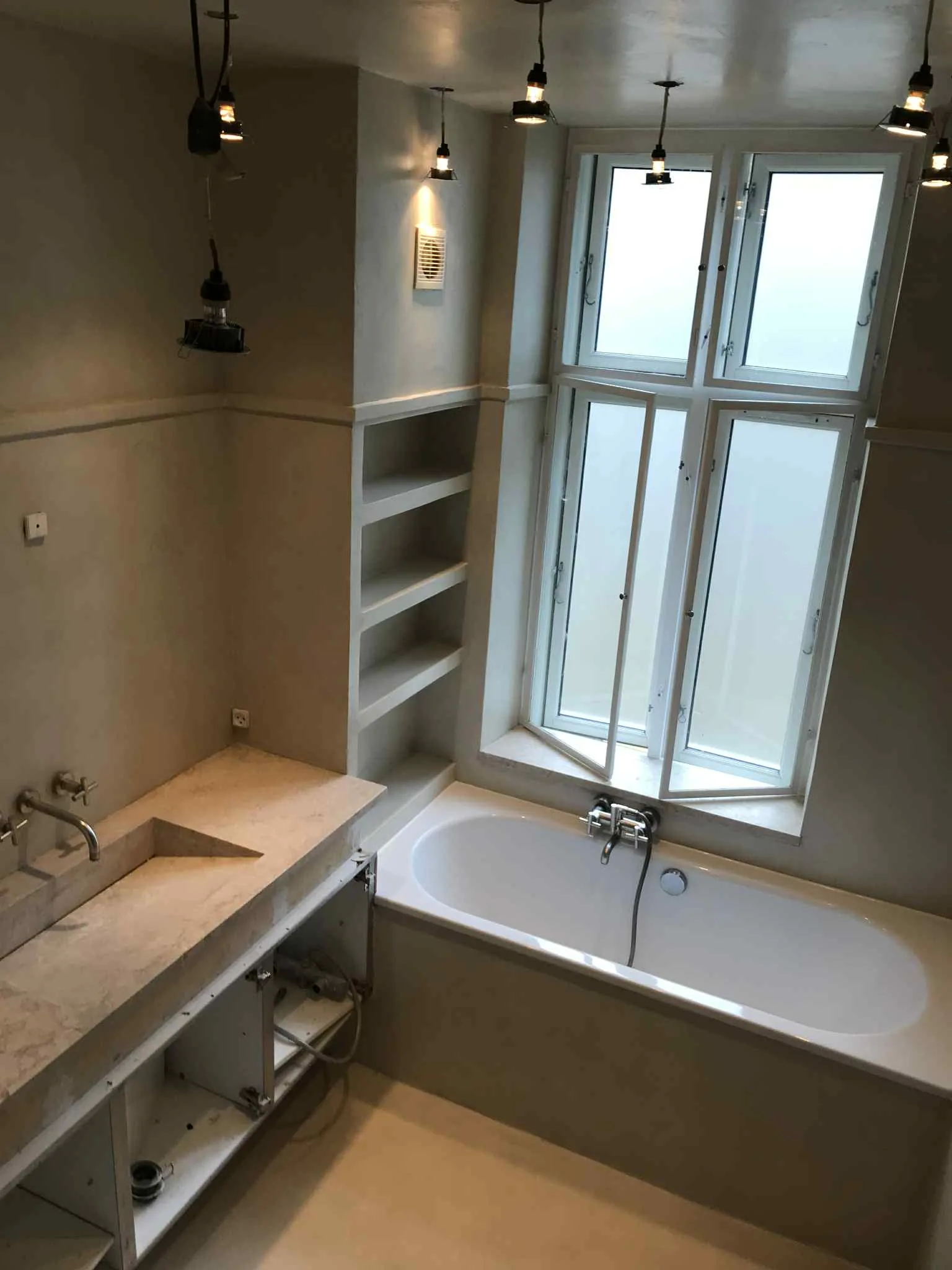 Microcement bathroom renovation in Marbella — continuous waterproof surface